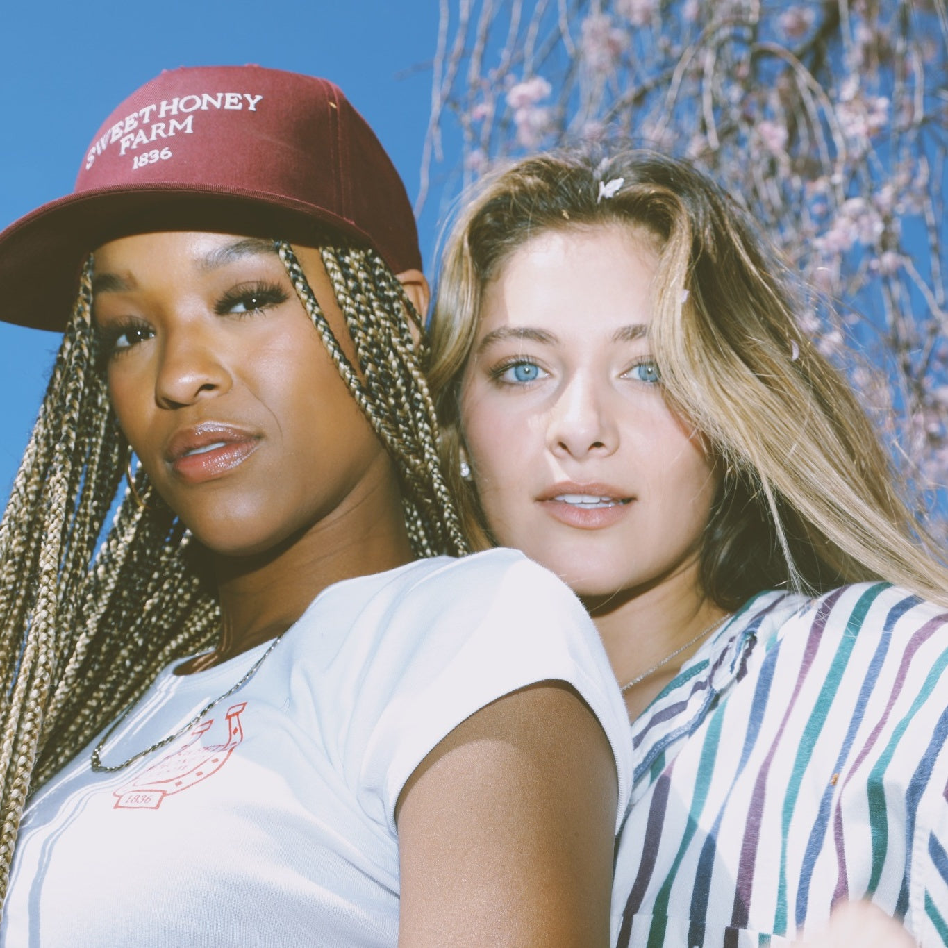 Close-up of two women in maroon snapback hats – Sweet Honey Farm